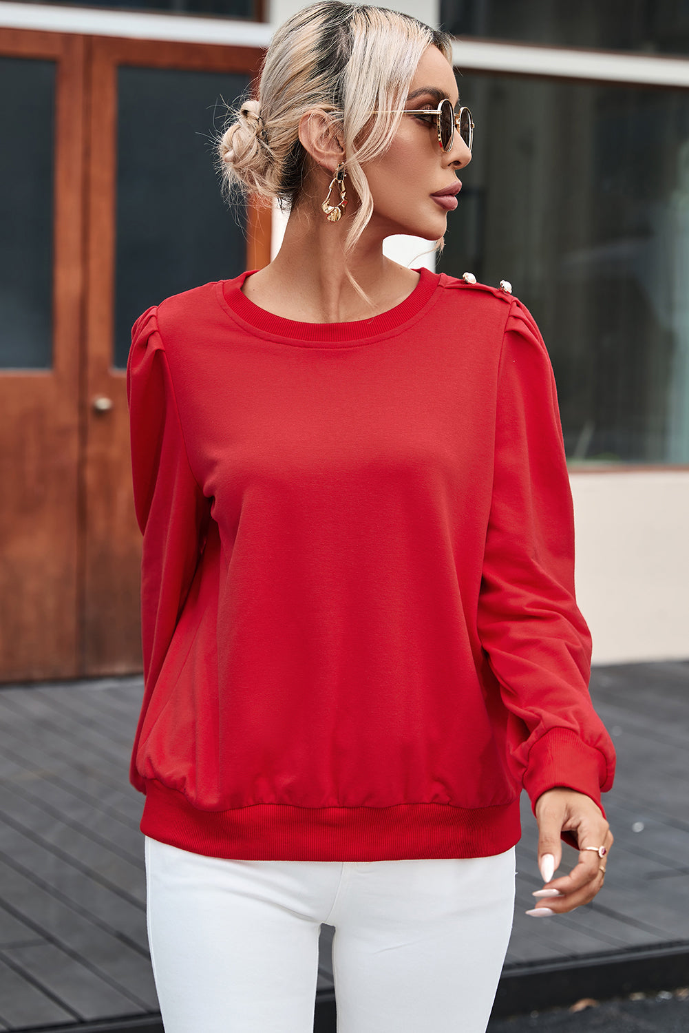 Blusa de manga larga con detalle de botón rojo