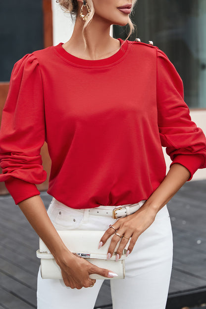 Blusa de manga larga con detalle de botón rojo