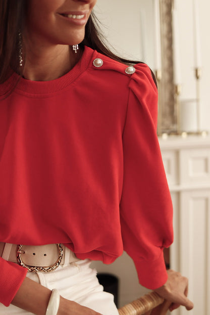 Blusa de manga larga con detalle de botón rojo