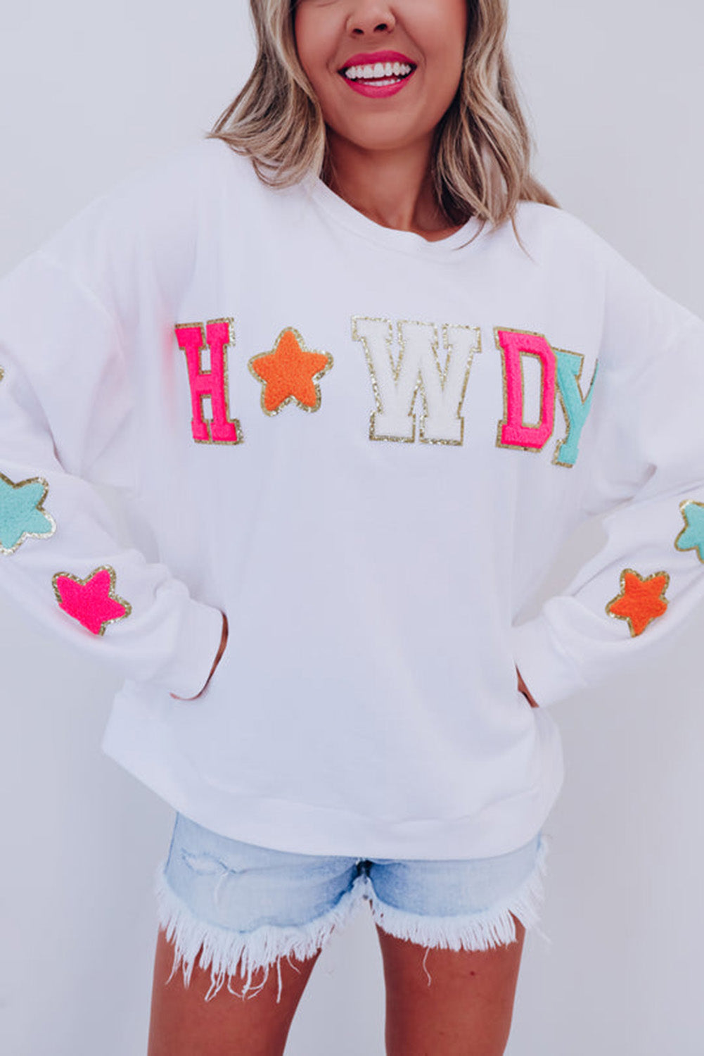 Vamp up your wardrobe with this fun pullover sweatshirt! The dazzling "HOWDY" graphic gives it a touch of pizzazz, and the star patterns on the sleeves make it extra darling. Made of 65% Polyester and 35% Cotton, you can choose from Black or White. Moodz Boutique has you covered!