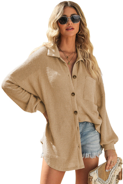 Stay comfortably cute in this lightweight, textured knit blouse. Featuring a button-up front, collared neckline, and drop shoulders, with a single accent chest pocket. Slouchy silhouette ending in a rounded hemline. Crafted from 95% polyester and 5% elastane.