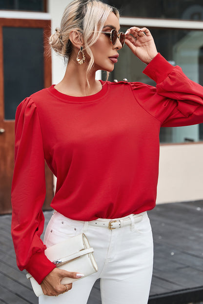 Blusa de manga larga con detalle de botón rojo