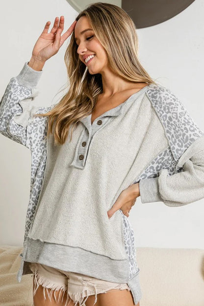 Sudadera con cuello abotonado y costuras expuestas con parches de leopardo en color gris