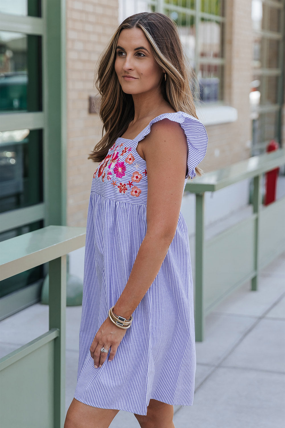 Vestido corto sin mangas con volantes, rayas y bordado floral en azul cielo