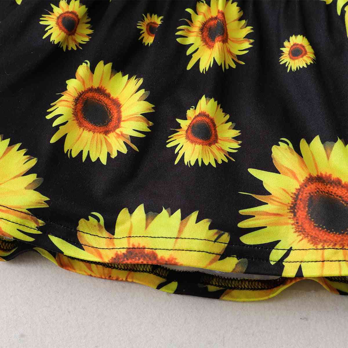 Conjunto de top con estampado de girasoles y pantalones cortos de mezclilla desgastados