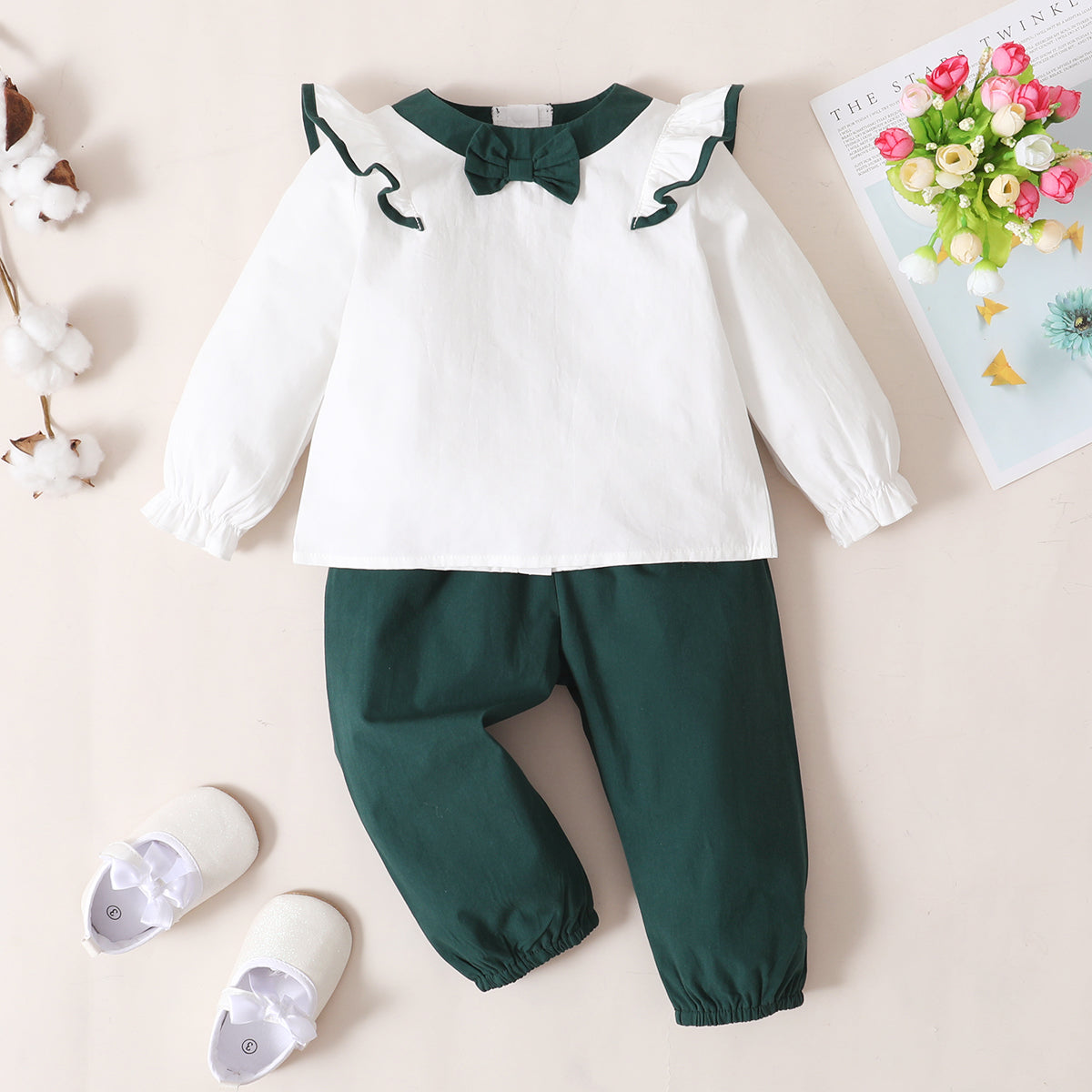 This two-piece set for babies and toddlers features a solid Bow Detail Top and Pants Combo with a stylish round neckline and long flounce sleeves crafted from 100% cotton. The cute ensemble also has a ruffle neckline for extra flair!