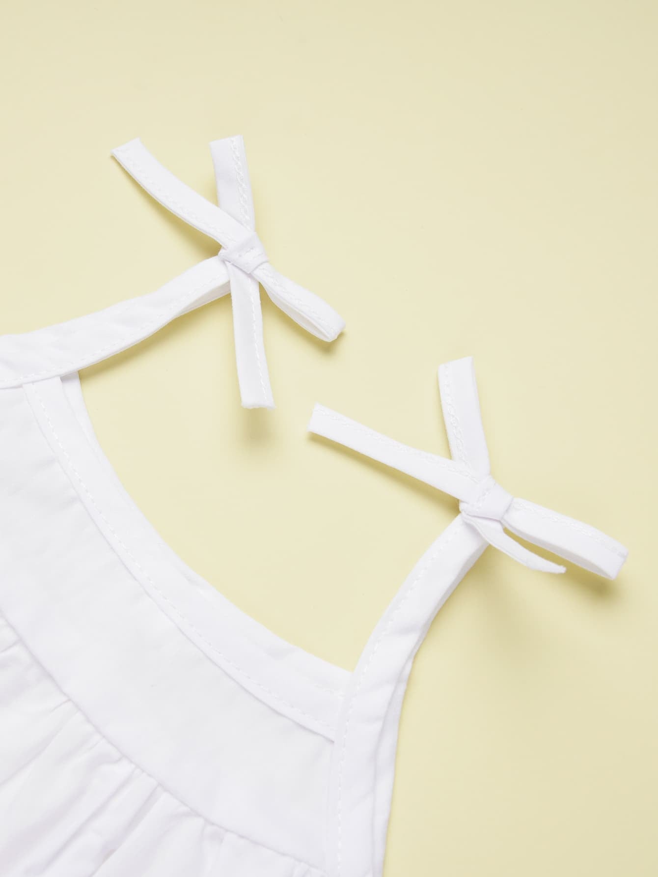 This supercute white Cami and Shorts Set features a bow, scoop neckline, and spaghetti straps. Crafted using a delightful blend of 95% cotton and 5% polyester, it's available in Baby and Toddler sizes.